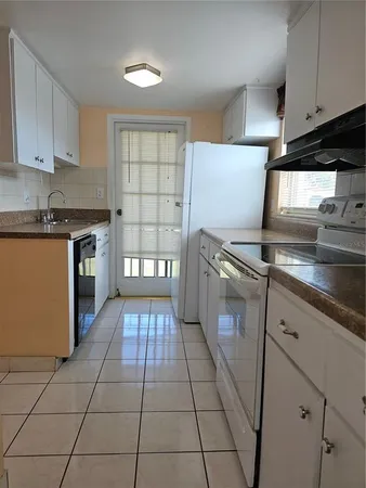 a kitchen with granite countertop a stove a sink and a microwave