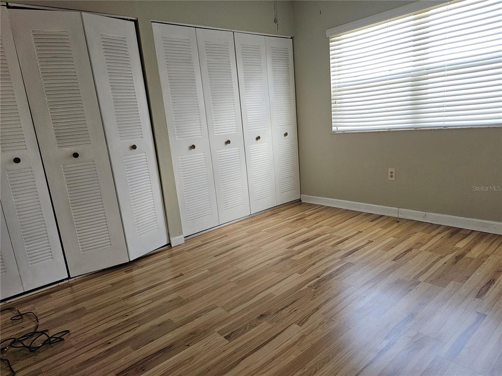 7701 Starkey Road, Unit 102 Seminole, FL 33777 - Photo 7 of 24 a view of an empty room with wooden floor and a window
