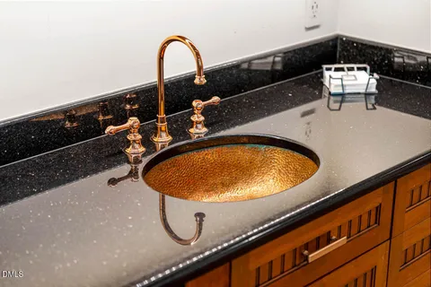 a bathroom with a granite countertop double vanity sink and mirror