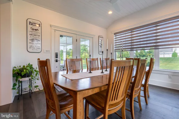 a view of a chairs and table in patio next to a yard