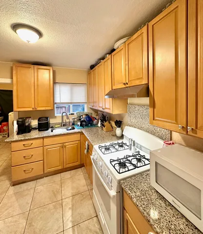 a kitchen with a stove a sink a refrigerator and cabinets