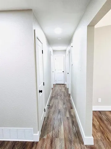 a view of a hallway with wooden floor and staircase