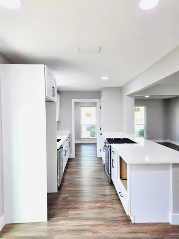 a view of a kitchen with a sink and wooden floor