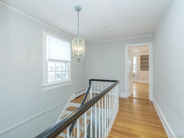 a view of a hallway view with wooden floor and staircase