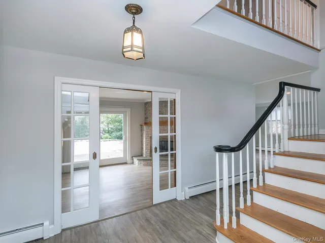 a view of a hallway with wooden floor and staircase