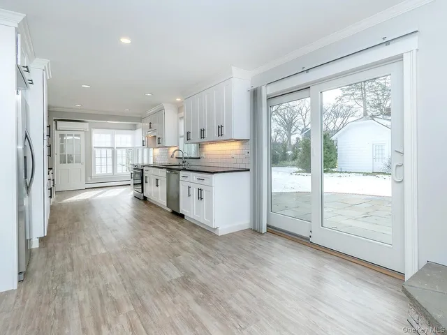 a view of a kitchen with wooden floor and a window