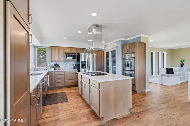 a kitchen with stainless steel appliances granite countertop a stove a sink and a refrigerator