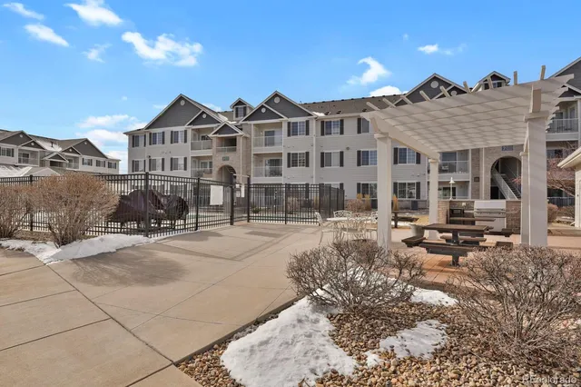 a view of a building with sitting area and garden