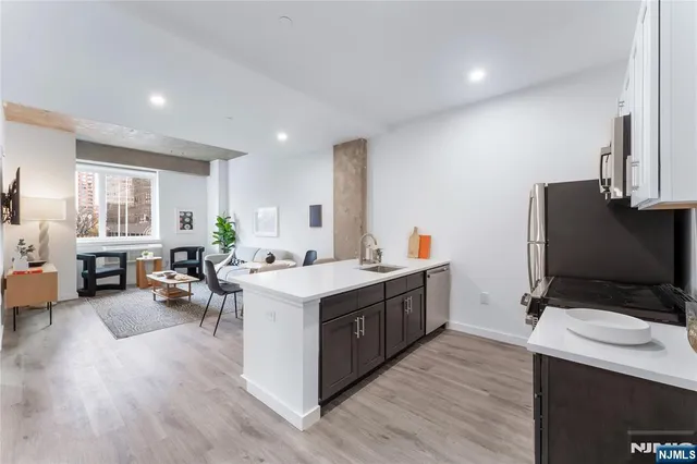 a kitchen with a sink stove and wooden floor