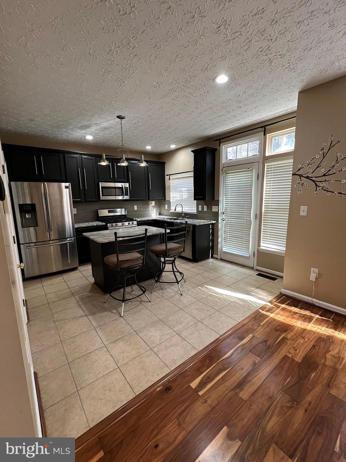 8334 Lyndhurst Street Laurel, MD 20724 - Photo 6 of 16 a living room with stainless steel appliances furniture a rug and a kitchen view