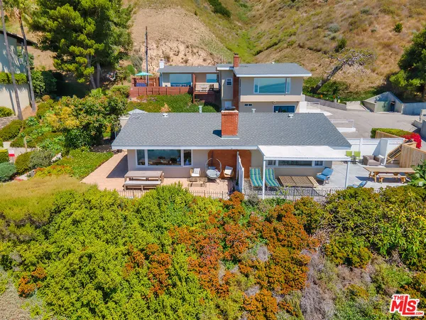 an aerial view of a house with a yard table and chairs