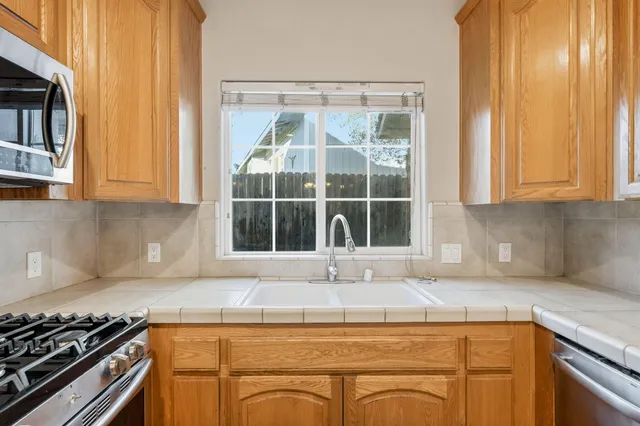a kitchen with granite countertop a sink and a stove
