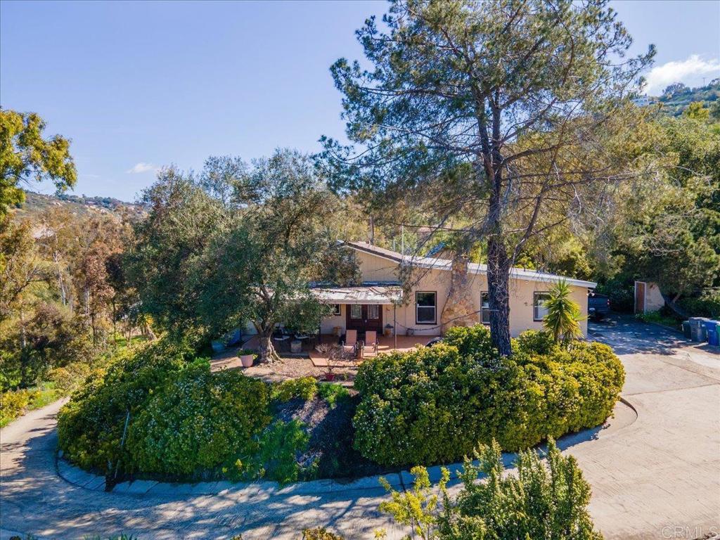 a front view of a house with a yard and fountain in middle