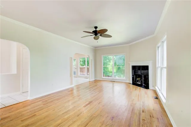 a view of an empty room with window and wooden floor