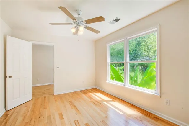 a view of a room with wooden floor and a ceiling fan