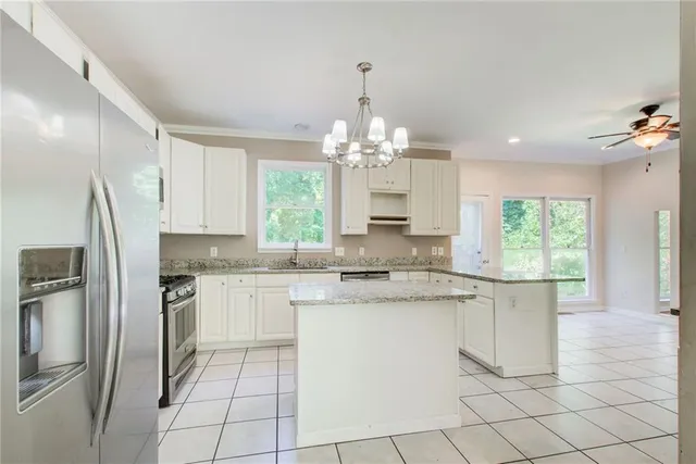 a kitchen with granite countertop a sink and white cabinets