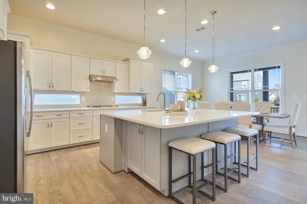 a kitchen with kitchen island granite countertop a sink cabinets and wooden floor