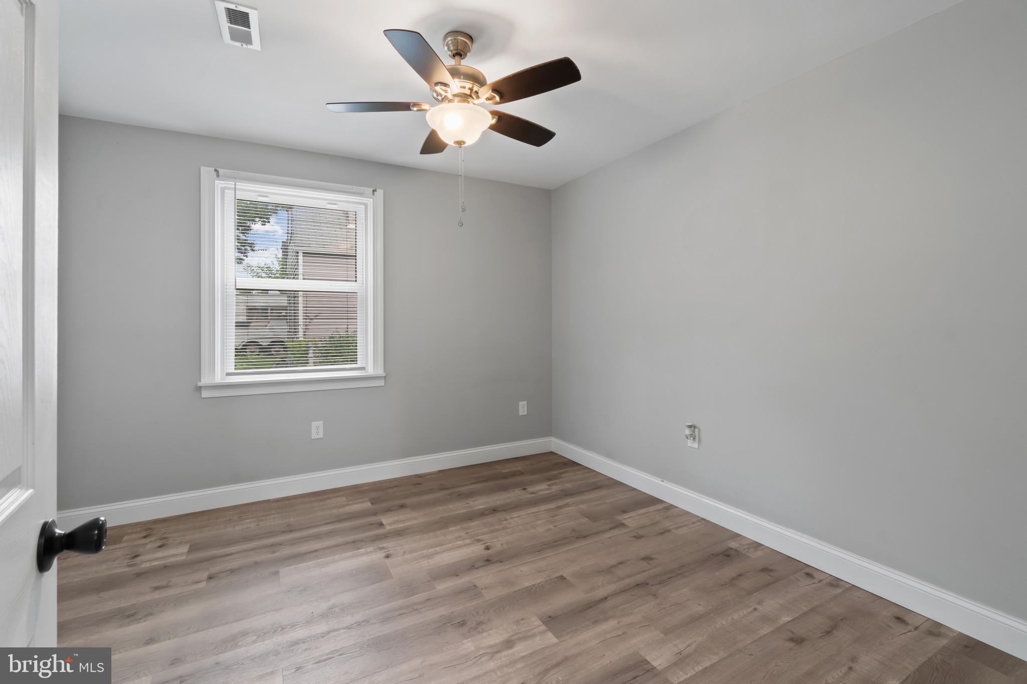 3412 Sollers Point Road Dundalk, MD 21222 - Photo 17 of 31 an empty room with wooden floor and windows