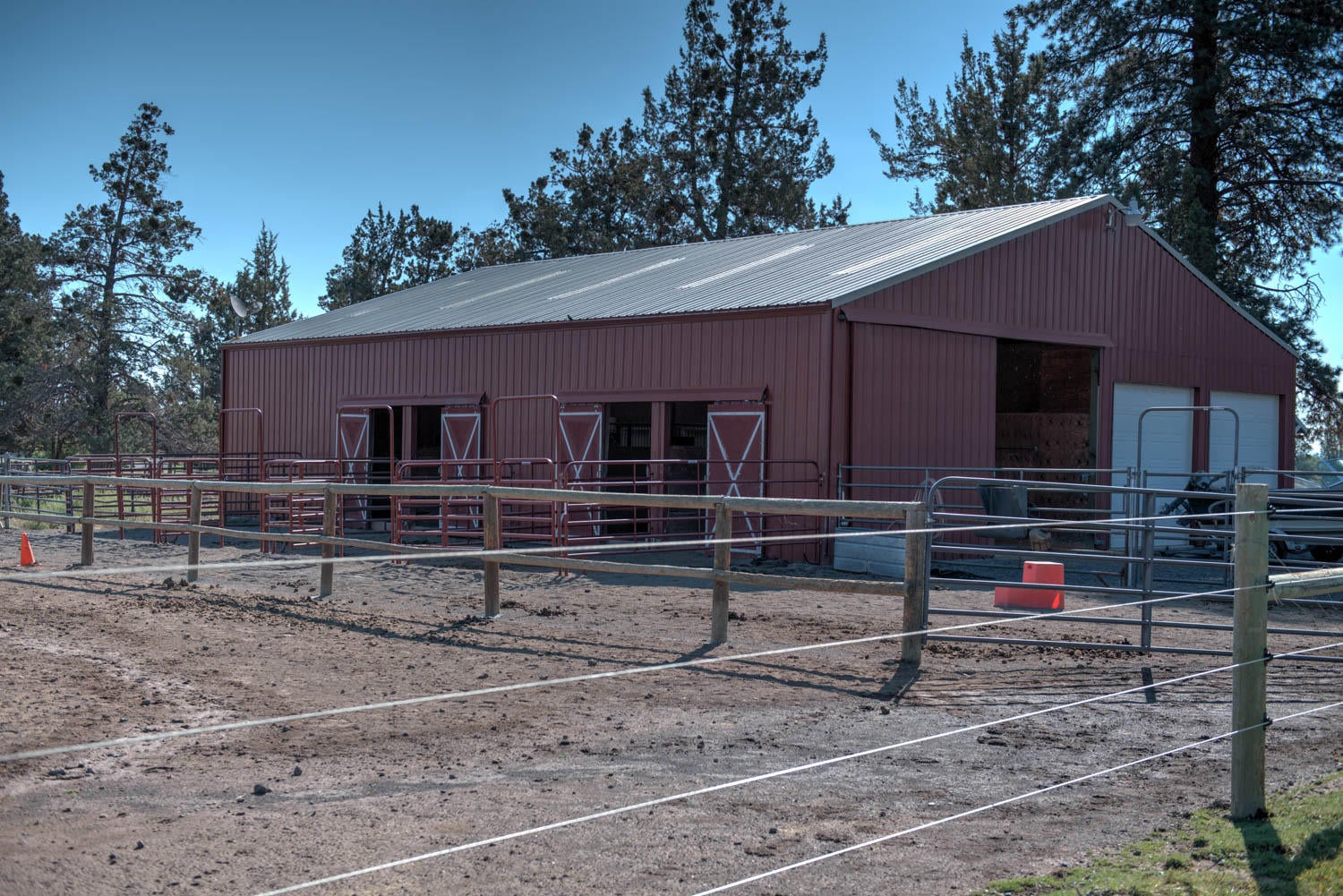 22222 Erickson Road Bend, OR 97701 - Photo 72 of 100 Barn with 4 stalls on west side, all with paddocks. Breezeway with doors for driving through. 850 sq ft insulated shop on right with 2 overhead doors
