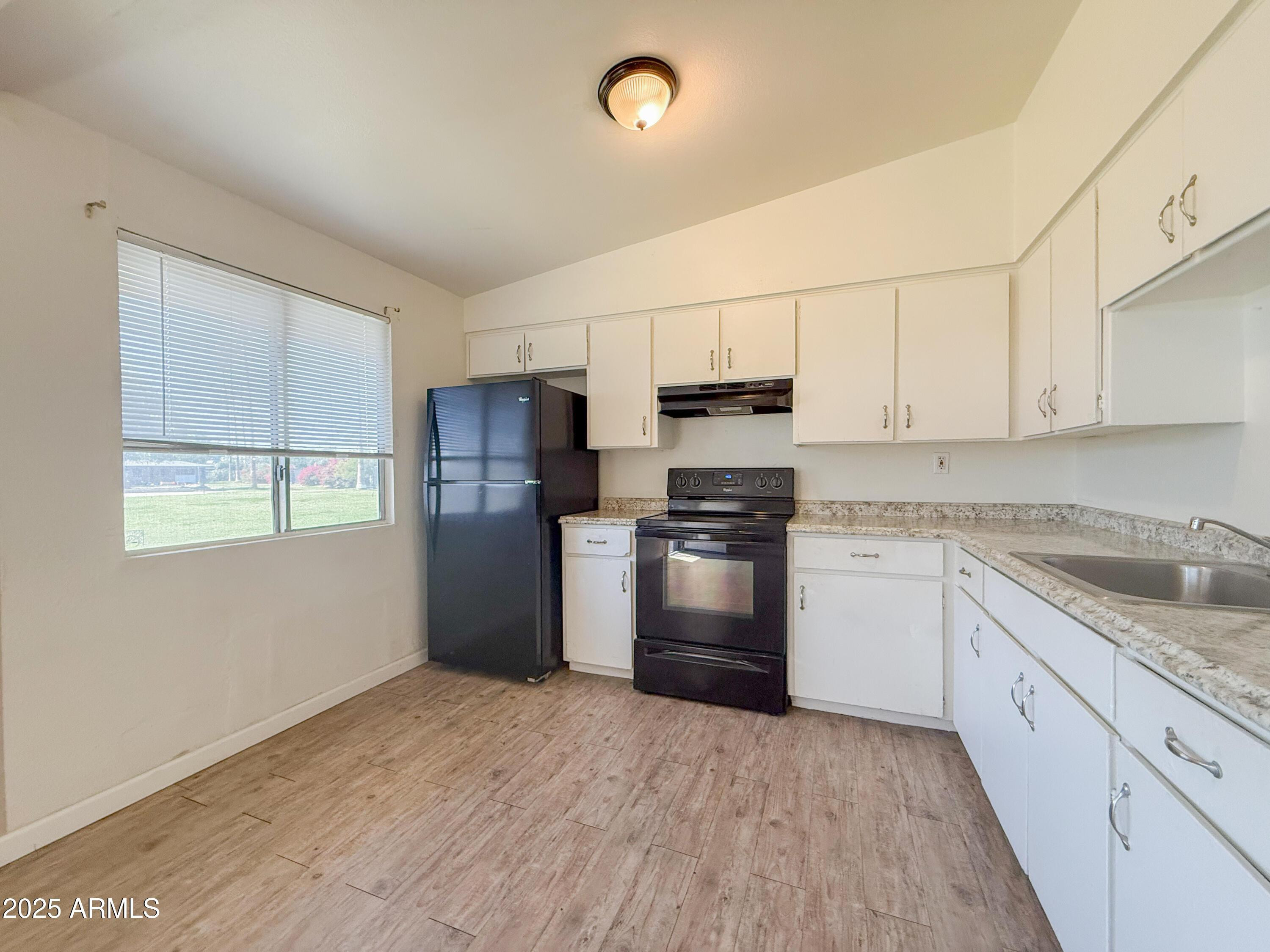 2123 West Devonshire Avenue, Unit 15 Phoenix, AZ 85015 - Photo 8 of 14 a kitchen with granite countertop a refrigerator and a stove top oven