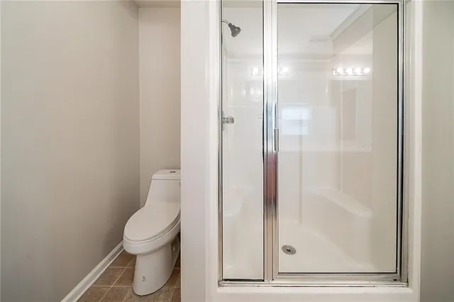 a bathroom with a toilet and a glass shower door