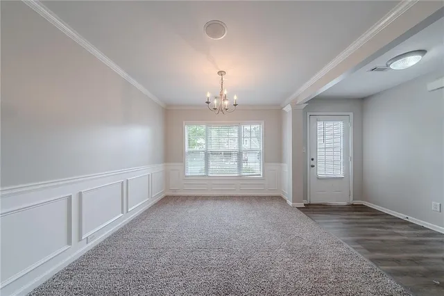 an empty room with windows and chandelier