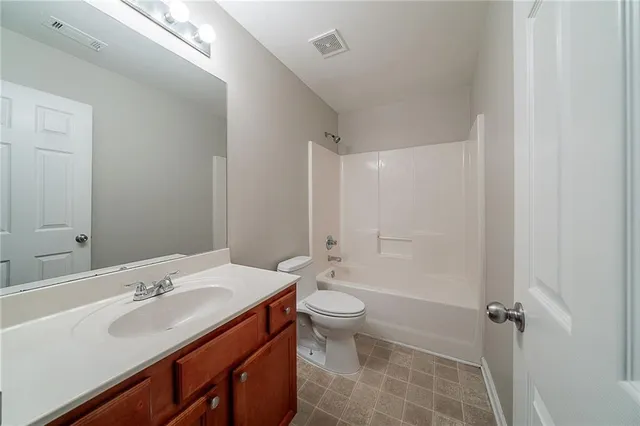 a bathroom with a double vanity sink toilet mirror and shower