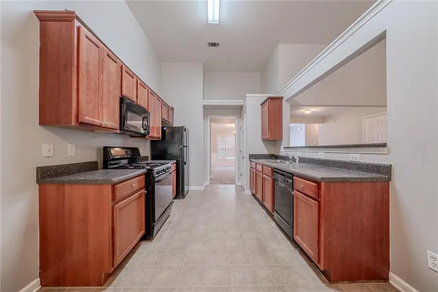 a large kitchen with stainless steel appliances granite countertop a stove a sink dishwasher and a refrigerator