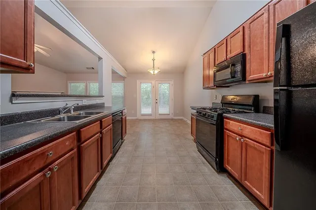 a large kitchen with stainless steel appliances granite countertop a stove and a sink