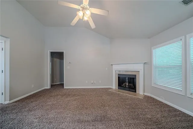 an empty room with fan and fireplace