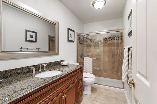 a bathroom with a granite countertop sink toilet and shower