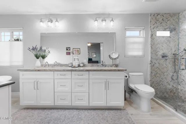 a bathroom with a granite countertop sink and a toilet