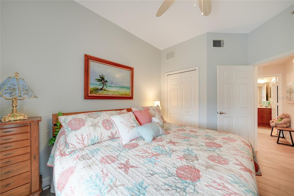 17094 Acapulco Road, Unit 313 Punta Gorda, FL 33955 - Photo 23 of 49 a bedroom with a large bed and a chandelier