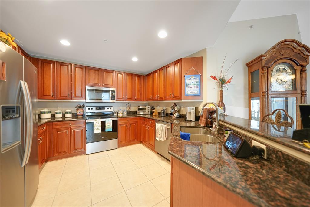 17094 Acapulco Road, Unit 313 Punta Gorda, FL 33955 - Photo 8 of 49 a open kitchen with stainless steel appliances granite countertop a stove sink and cabinets