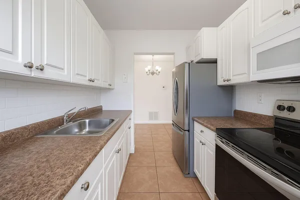 a kitchen with granite countertop a sink stove and refrigerator