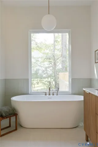 a white bath tub sitting in a bathroom next to a window