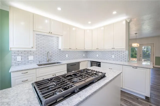 a kitchen with kitchen island a sink stove and cabinets