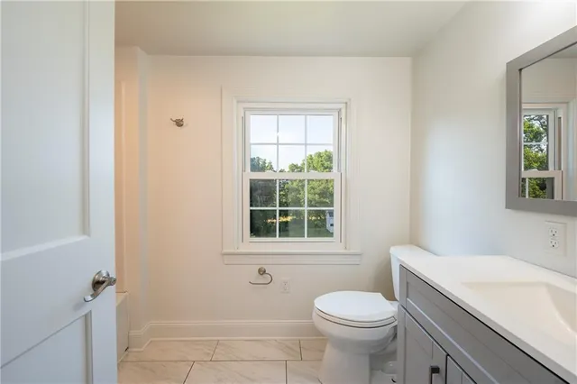 a bathroom with a sink toilet and window