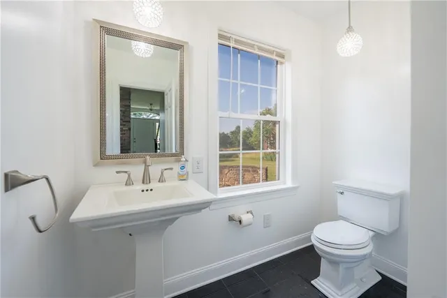 a bathroom with a toilet sink and mirror