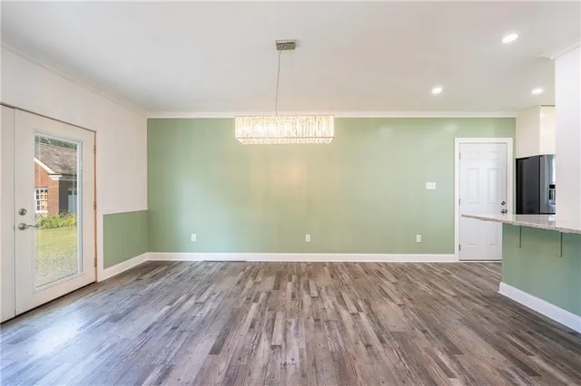 a view of a room with wooden floor and a window