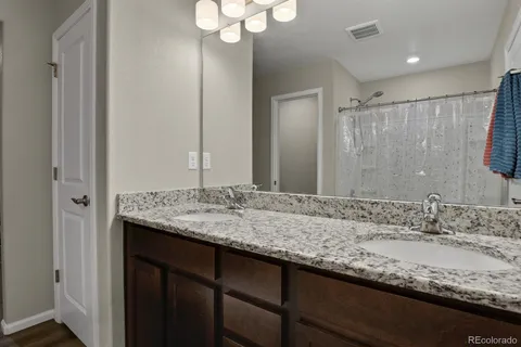 a bathroom with a granite countertop sink and a mirror
