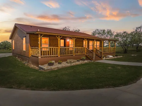a front view of a house with a garden and yard