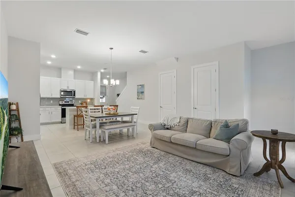 a living room with furniture and view of kitchen