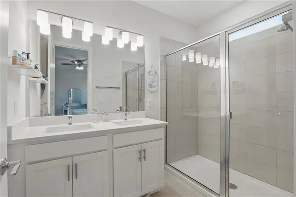 a bathroom with a shower sink vanity and mirror