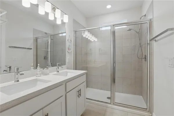 a bathroom with a shower sink vanity and mirror