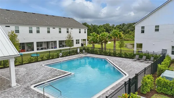 a view of a house with pool and chairs