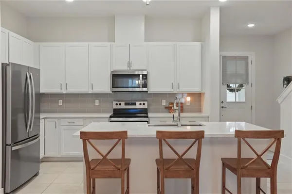 a kitchen with stainless steel appliances a stove a sink cabinets and a refrigerator