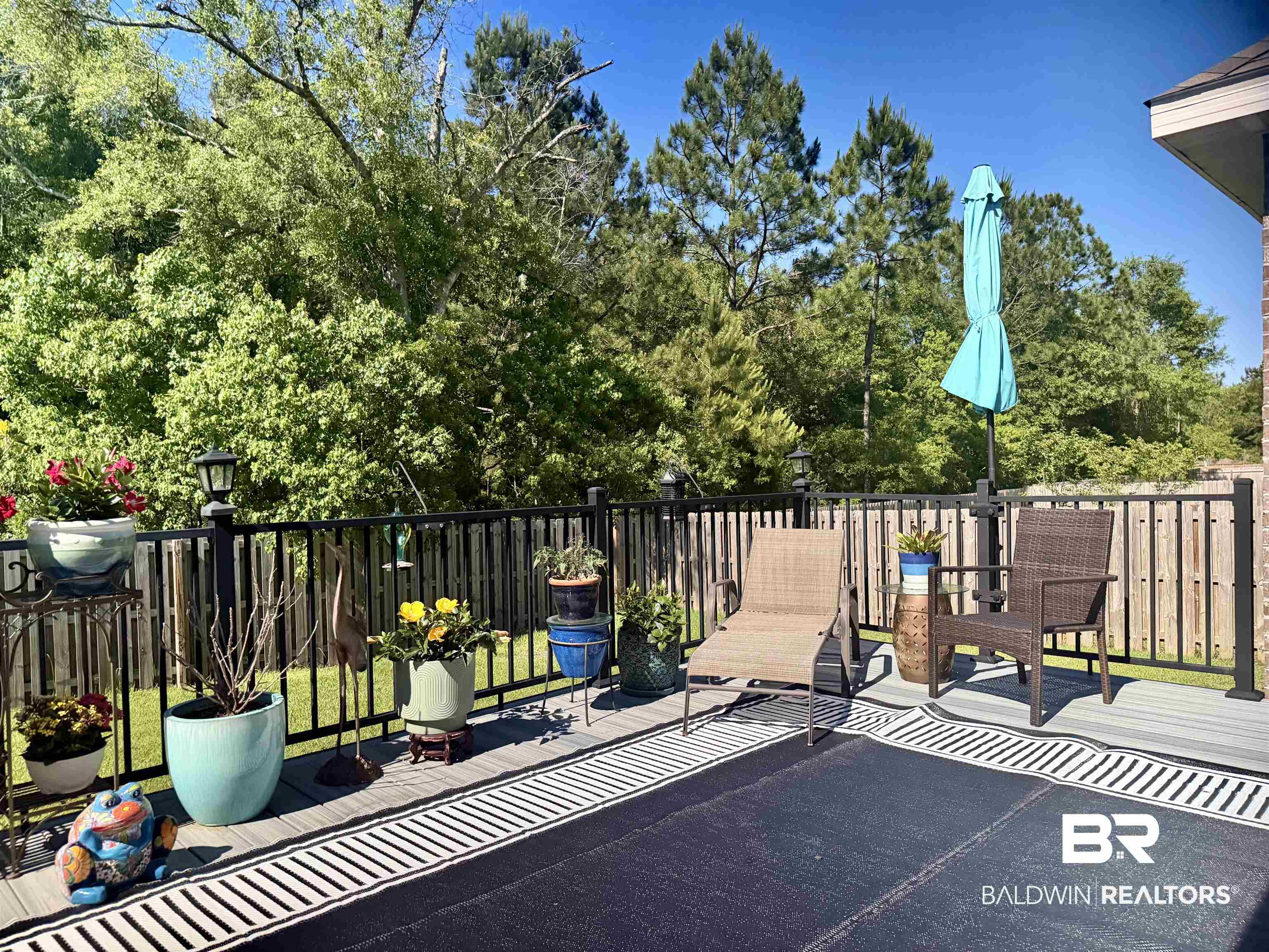 8827 Calverton Street Foley, AL 36535 - Photo 41 of 57 Spacious outdoor deck featuring light grey composite decking, black aluminum railings, and a privacy fence