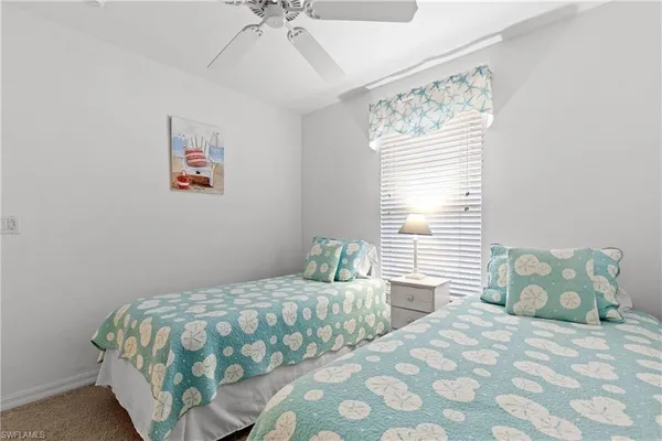 a bedroom with two beds and a window