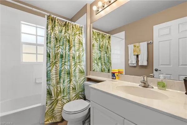a bathroom with a granite countertop sink a toilet and a mirror